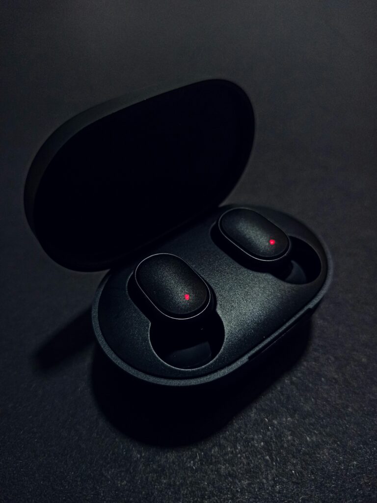 Sleek black wireless earbuds with charging case on a dark background, perfect for music lovers.