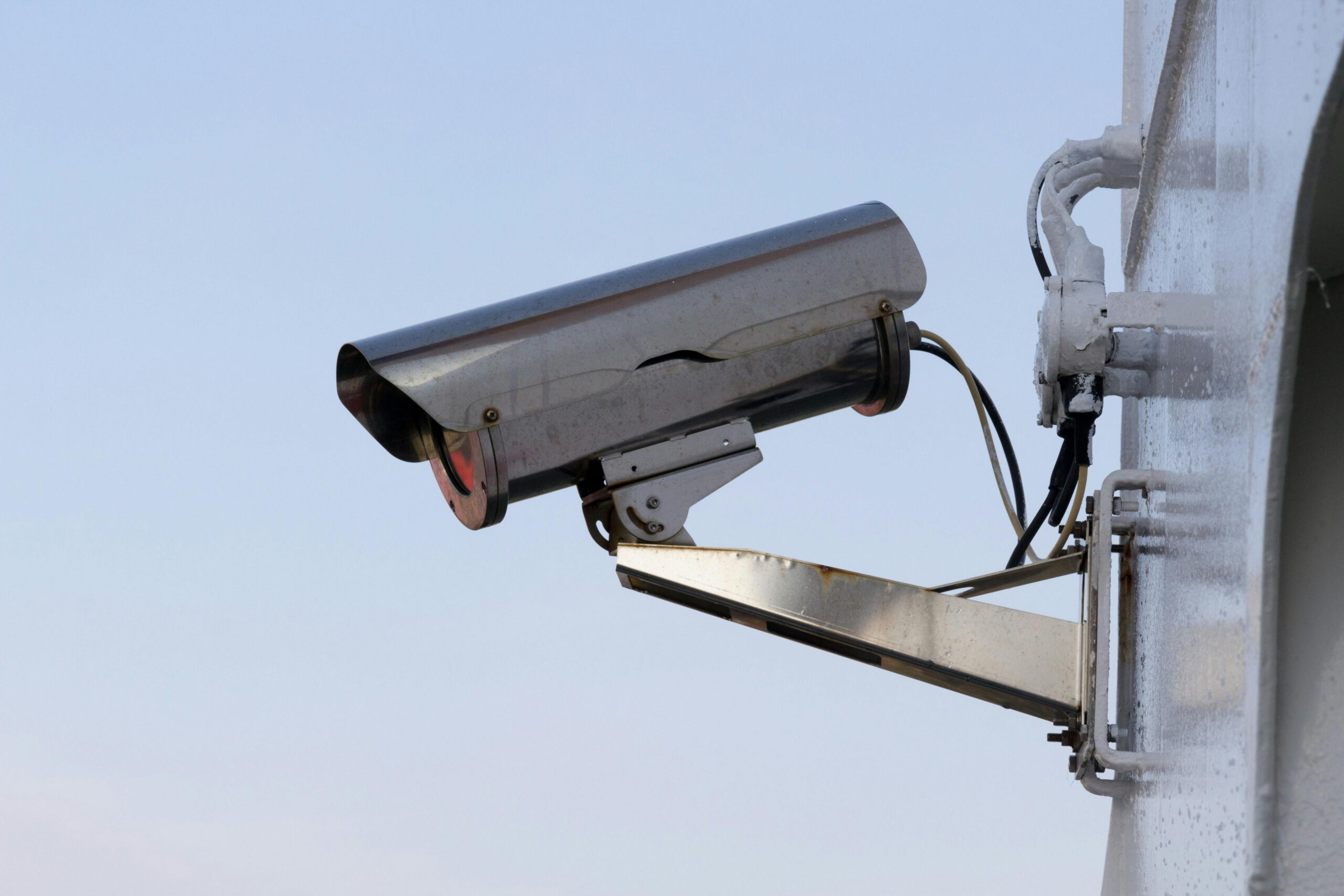 Close-up of an outdoor CCTV camera installed on a wall for security purposes.